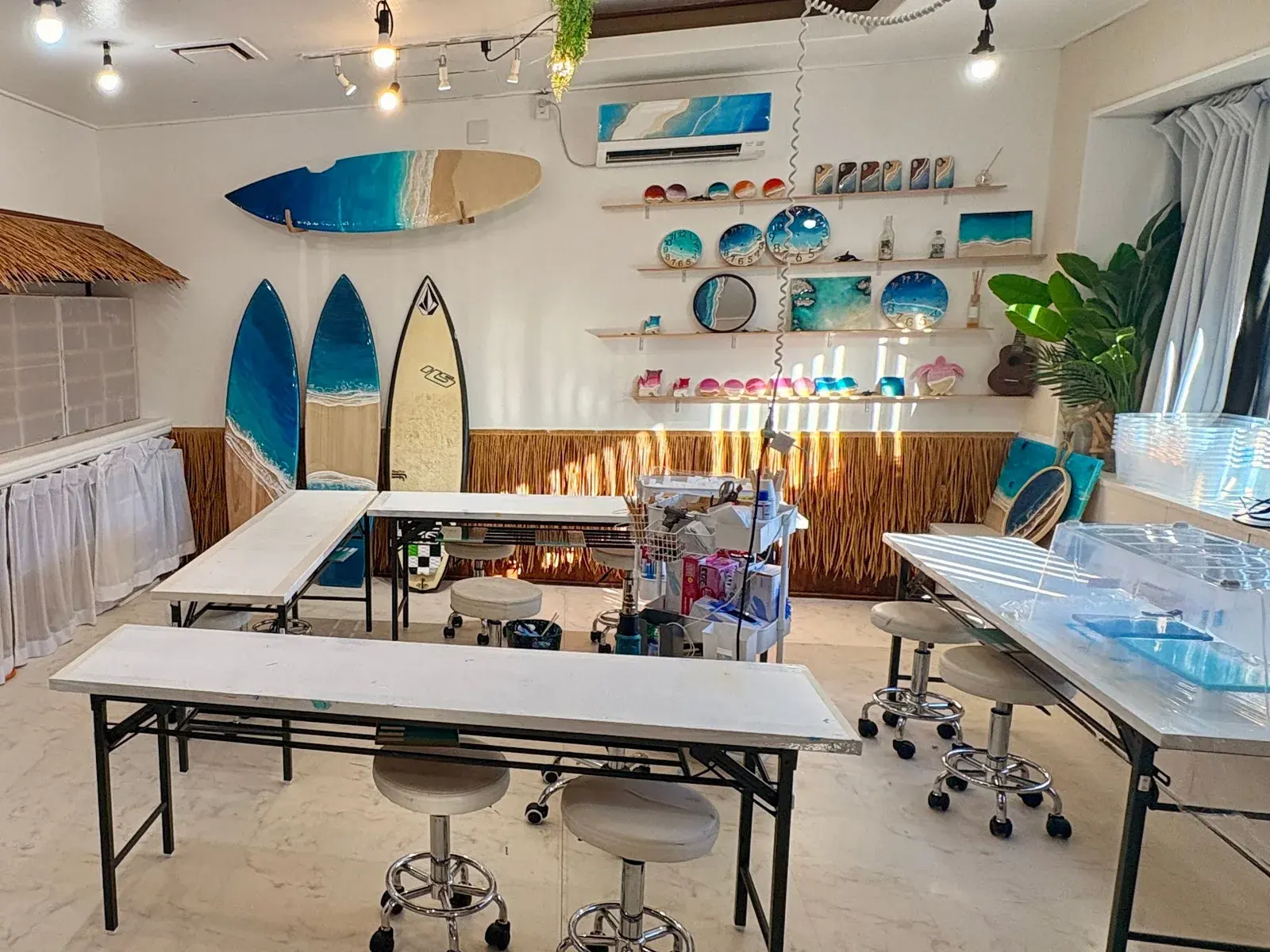 海のレジンアートやサーフボードが飾られた宮古レジンの店内と制作テーブル